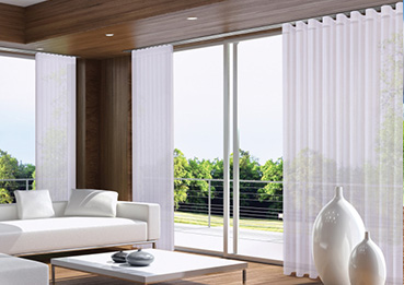 Gemütliches Wohnzimmer mit grossem Fenster und einer einladenden Couch.